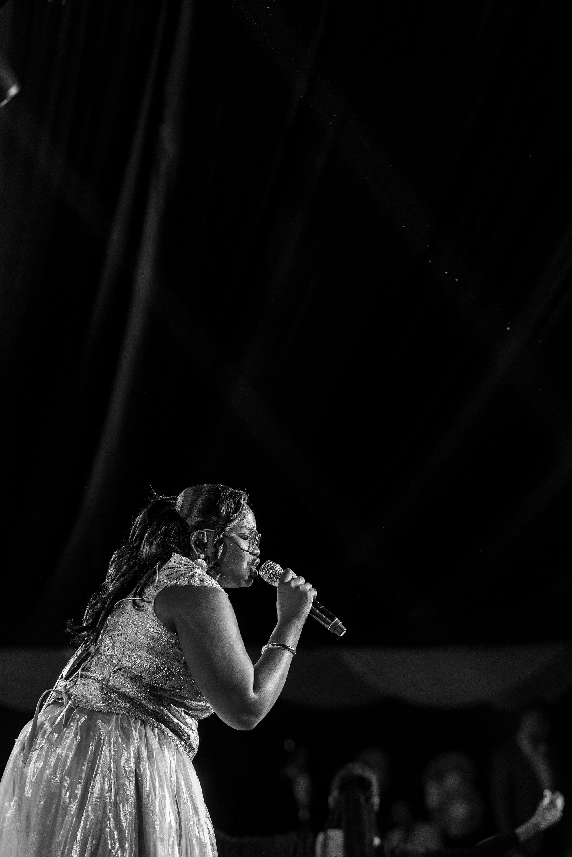 Close-up of Purity Atieno singing into a microphone