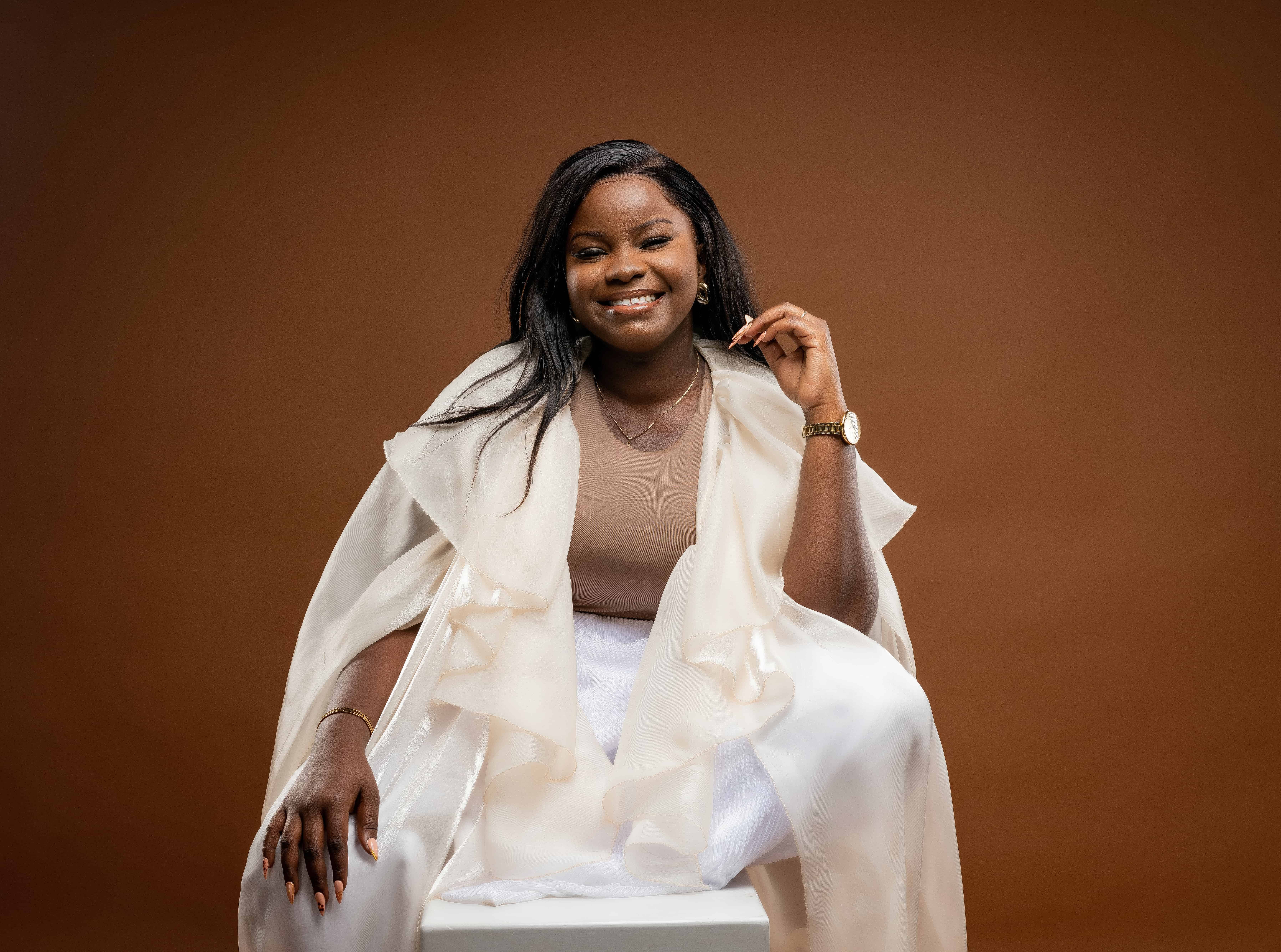 Studio portrait of Kenyan musician Purity Atieno in a gold-print jacket